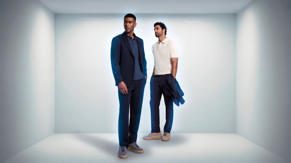 Homens em uma sala branca vestindo roupas tecnológicas.