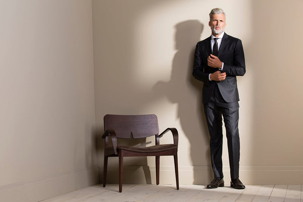 Homem elegante em uma sala vestindo um traje passeio completo.